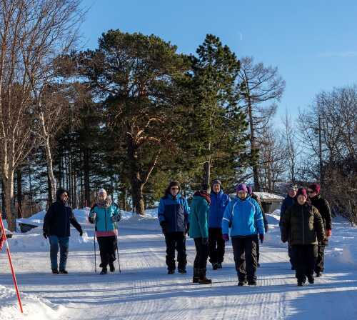 Fornøyde damer og menn går på tur i fint vintervær på Skjerstad