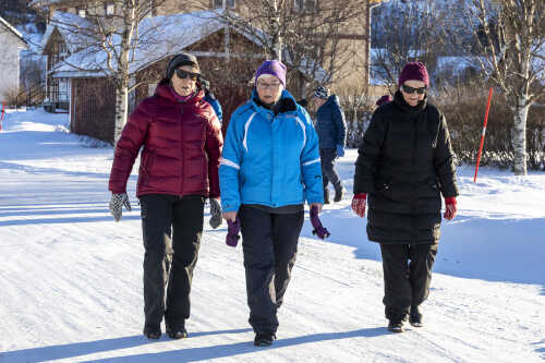 Fornøyde personer går på tur i fint vintervær på Skjerstad